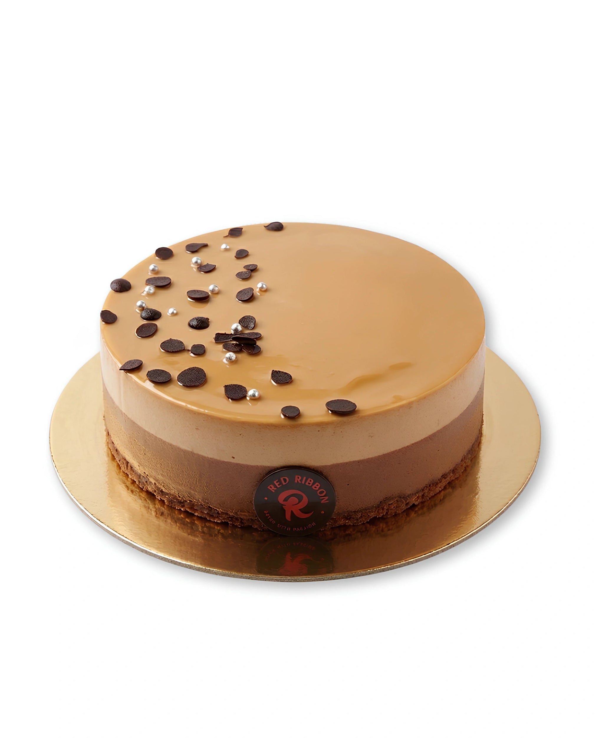 Chocolate mousse cake with layered light and dark chocolate mousse, glossy caramel glaze, chocolate flakes, silver pearls, and a smooth round finish on a gold cake board