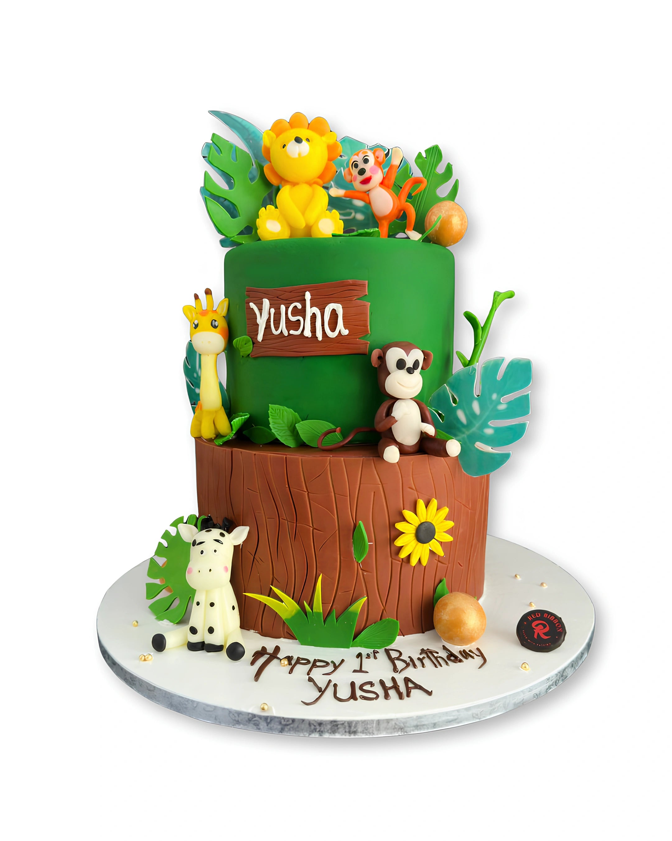 Jungle Safari themed tier cake by Red Ribbon Cakes with animal figurines and forest design, custom first birthday cake in Dubai