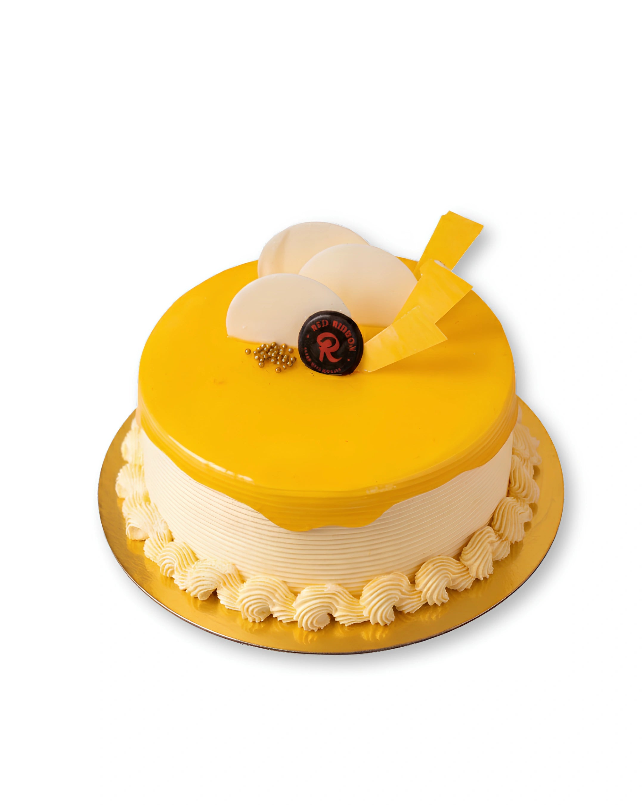 Mango delight cake with glossy mango glaze, smooth cream frosting, white chocolate decorations, and elegant whipped cream borders on a gold cake board