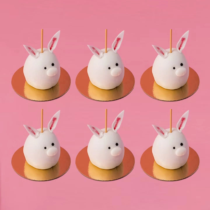 easter bunny cake pops with white chocolate coating and cute rabbit design on pink background, red ribbon cakes & bistro dubai